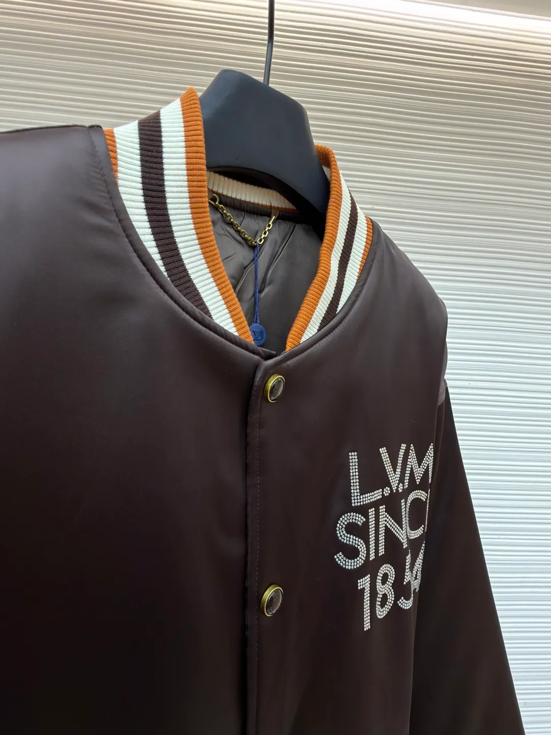 LOUIS VUITTON decorative flight jacket ●Original version: 30,000 purchased and developed ●Item number: 1682285-B90 ●Fabric: cotton fabric ●Technology: patch production ●Color: brown ●Version: fitted version ●Weight: about 1085 grams ●Size: 46-48-50-52 ●Description: The main body of this Louis Vuitton satin baseball jacket is made of high-density matte satin fabric, which has been treated with anti-wrinkle shaping technology. The fabric has a strong drape and is not easy to wrinkle. The dark brown background color is prepared by precision dyeing and finishing technology, giving it a rich color and high-end texture. The "L.V.M SINCE 1854" logo on the left chest is made with hot-drilling technology. High-quality rhinestones are used for precise hot-pasting in different areas. The diamond surface is shiny and strong and will not fall off easily. The ribbed splicing of the collar, cuffs and hem is a three-color contrasting design. It is woven with high-elastic knitted yarn, which will not easily loosen and deform after long-term wear. The placket is equipped with custom-made metal snaps. The hardware is thick and anti-oxidation. The overall style is loose and off-shoulder. The splicing is covered with blind stitching technology, and the wiring is smooth and traceless. Every craft detail follows the brand's luxury product production standards, taking into account both design and wearing comfort. The overall wiring is straight and delicate, the fabric is comfortable and soft, and the color is consistent without color difference. It can be matched with the same style to create a fashionable look and control various occasions. Customized accessories, complete with three standards, same style for men and women!